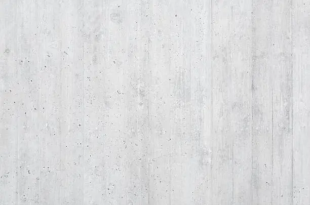 Close-up of a high-quality board formed concrete wall with vertical wooden texture impressions. Soft lighting with excellent detail useful both as a background and as a high-frequency texture.