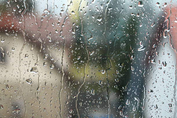 istock Rain drops on window with house and church in background 508949622