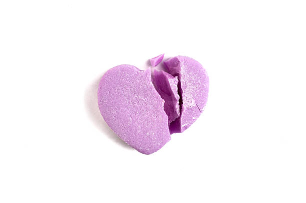istock Broken Valentine's Day purple candy heart on white background 508957468