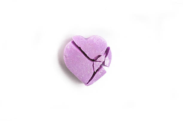 istock Broken Valentine's Day purple candy heart on white background 508957574