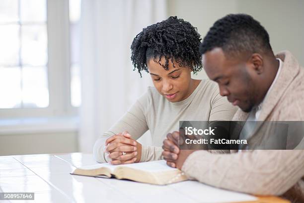 Religious Ethnic Couple Praying With A Bible Stock Photo - Download Image Now - Praying, Christianity, African-American Ethnicity