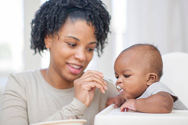 istock Mother Spoon Feeding Her Baby Son 508957670