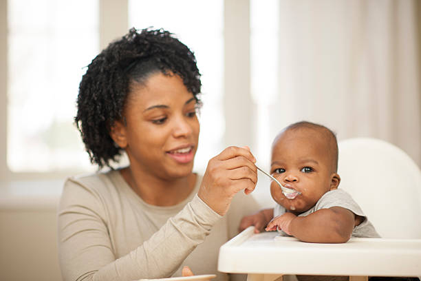 istock Mother Spoon Feeding Her Baby Son 508957698