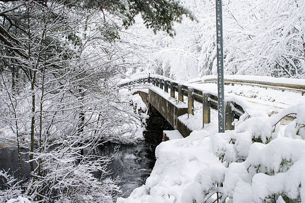 istock Fairytale Bridge Crosses Rushing River Maine Snowy Scene 508959122