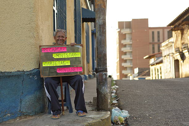 San Cristobal, Venezuela - February 8, 2016: Common informal worker on 4th Street of La Guacara Sector in San Cristobal, Venezuela on Carnival Monday, February 8th 2016 selling cards and recharge balance for mobile phones. This kind of job is one of the most popular in the informal business part of the economy in the country because of its high sales rate. Venezuela has 106 connections per 100 people according to 2014 official Venezuelan Goverment from Ministry of Communications and Information.