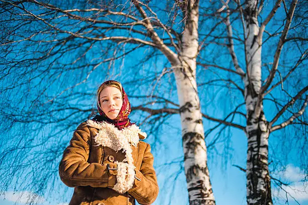 Photo of Beautiful blond woman in russian winter suit stay near the