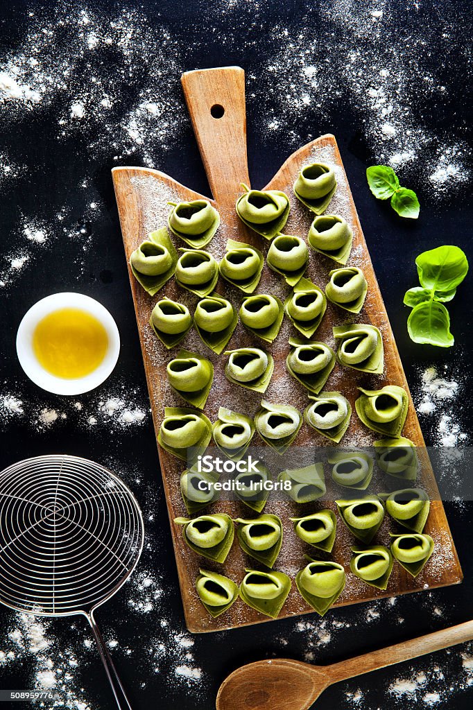 green tortellini with spinach and ricotta before boiling. green tortellini with spinach and ricotta before boiling. raw filled pasta. Healthy Italian food Basil Stock Photo