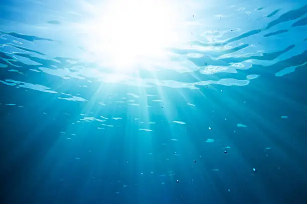 Photo of sun and sunbeams in the ocean water