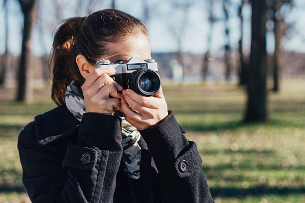 istock Woman taking a photo with old analog camera 508961292