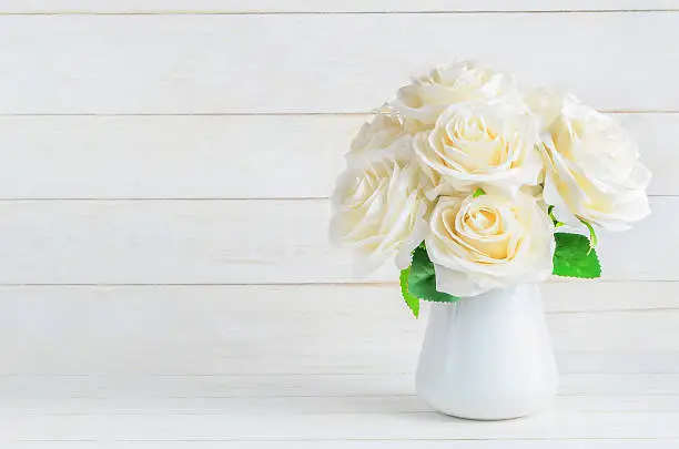 Photo of White artificial roses in vase
