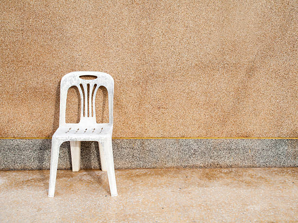 istock white chair and concrete wall 508964873