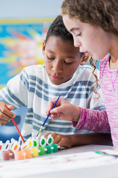 istock Elementary school children in art class painting 508966800