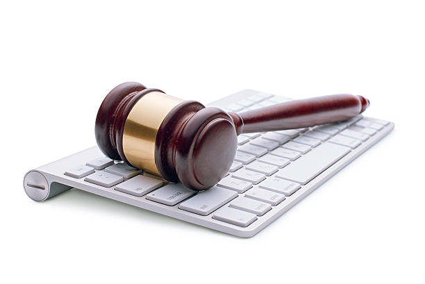 Wooden gavel on a white computer keyboard Wooden gavel on a white computer keyboard conceptual of online auctions or law enforcement and justice over the internet and punishment of cyber crime, on a white background gavel keyboard stock pictures, royalty-free photos & images