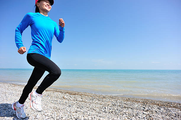 jogging in th beach - woman runns near sea on early summer morning