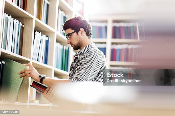 Wählen Sie Ein Buch In Der Bibliothek Stockfoto und mehr Bilder von Aussuchen - Aussuchen, Bibliothek, Bildung
