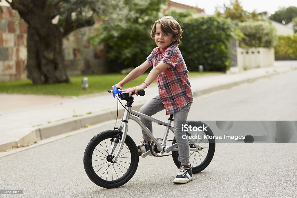 Confident boy sitting on bicycle Portrait of confident boy sitting on bicycle Child Stock Photo