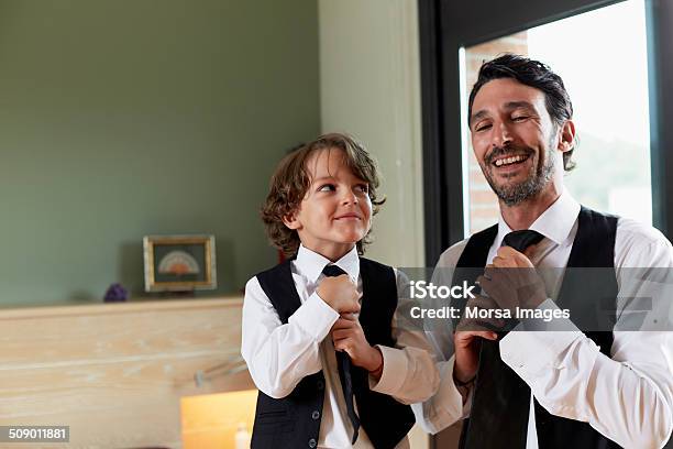 Boy Adjusting Tie While Looking At Father Stock Photo - Download Image Now - Imitation, Father, Child