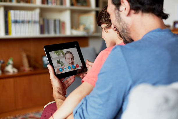 father and son using digital tablet on sofa - digital tablet family father offspring ストックフォトと画像