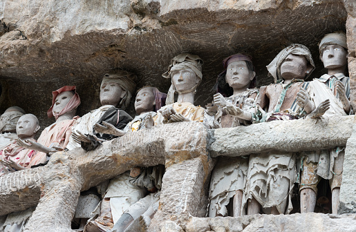 Wooden statues of Tau Tau are representatives of the deceased and guard the tombs. Suaya is cliffs old burial site of the royal family of Sangalla in Tana Toraja. South Sulawesi, Indonesia