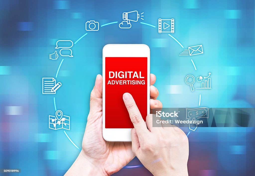 Hand holding smart phone with Digital Advertising word and icon Hand holding smart phone with Digital Advertising word and icon on blue pixel blur background, Digital Marketing concpet. Sharing Stock Photo