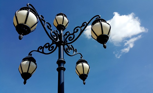 Antique lamppost on blue sky background