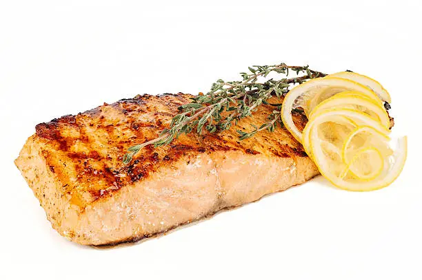 Salmon steak with lemon and rosemary on white background