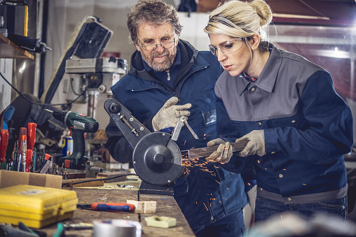 Mujer joven en taller mecánica de Metal pulido photo