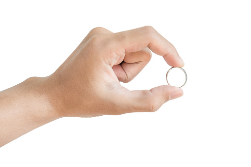 Hand holding silver ring, isolated on white background