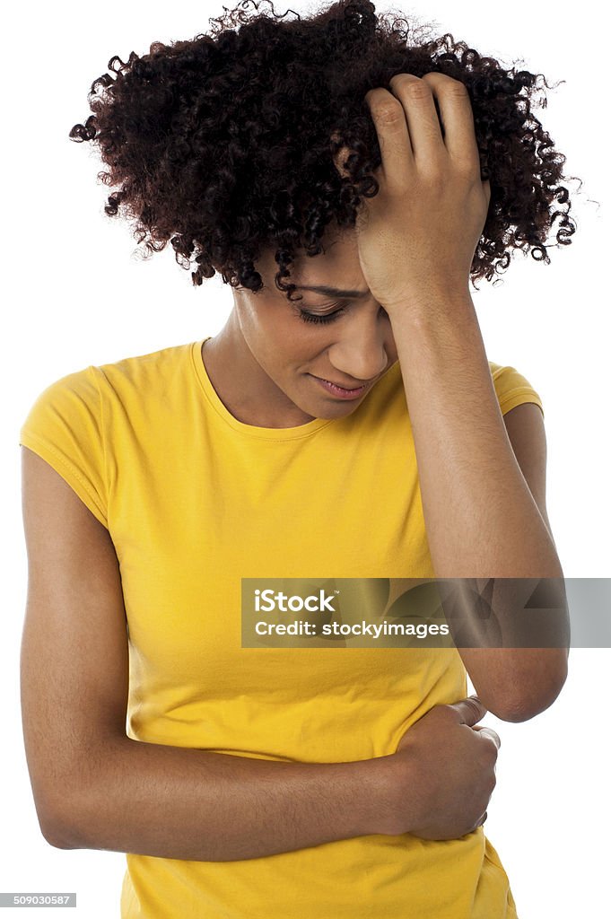 Young woman suffering from headache Expression of a young lady suffering from headache, pressing palm against her forehead. Adult Stock Photo