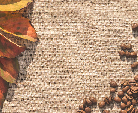 A scattering of coffee beans  on a background of linen. The idea of a menu design for a romantic cozy cafe