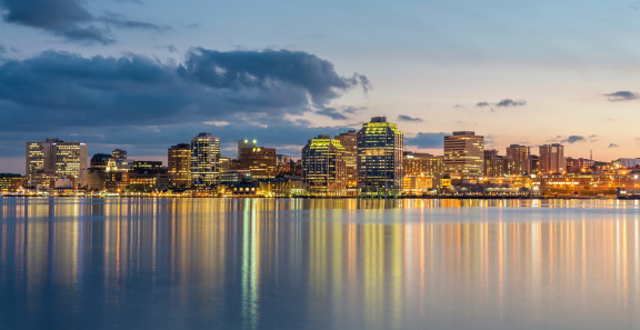 Panoramic Skyline of Halifax City illuminated at night reflecting in the water of Halifax harbour. Halifax, Nova Scotia, Canada.