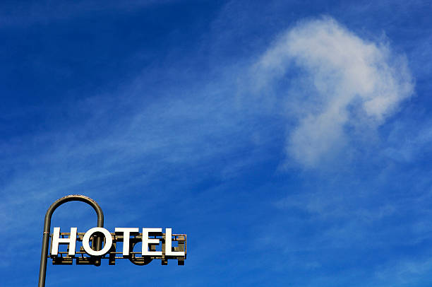 istock Hotel sign and fluffy cloud against blue sky 509033144