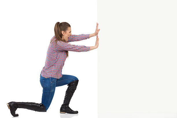 mujer en camisa de leñador empujando pared - pushing women wall people fotografías e imágenes de stock
