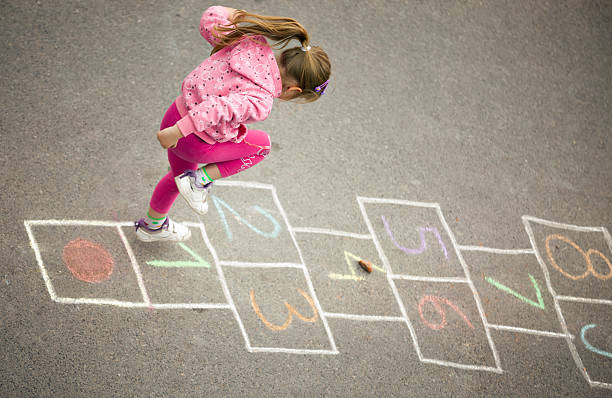 girl on the rayuela - little girls sidewalk child chalk fotografías e imágenes de stock