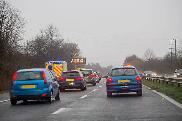 Road Accident Ambulance Parked on the Hard Shoulder of the M4 Motorway, UK. Traffic Queuing.  traffic car traffic jam uk stock pictures, royalty-free photos & images