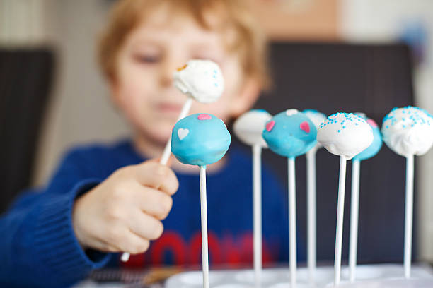 istock Little blond boy eating colorful cake pops. 509035029