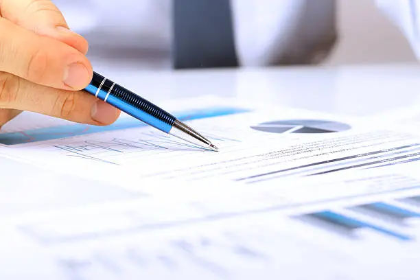 Photo of Businessman showing graphs by pen