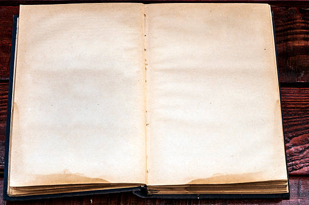istock Vintage book, open, on old wooden table. 509038638