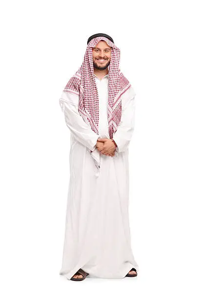 Full length portrait of a young Arab in a white robe and a red veil isolated on white background