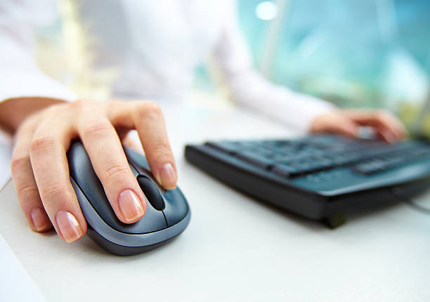 Computer work Image of female hands clicking computer mouse computer mouse photos stock pictures, royalty-free photos & images