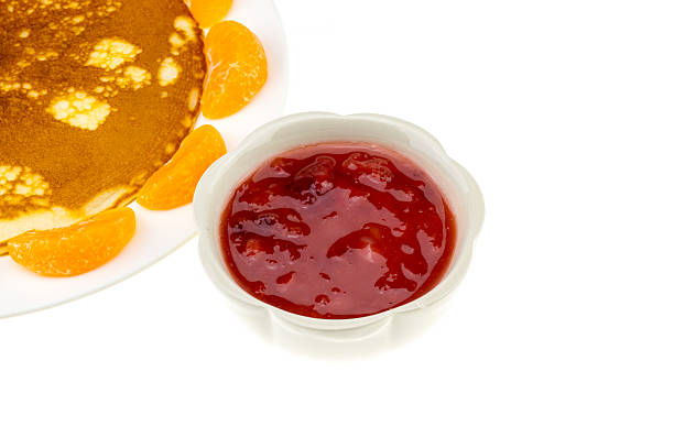 pancake and orange and strawberry sauce on white plate stock photo