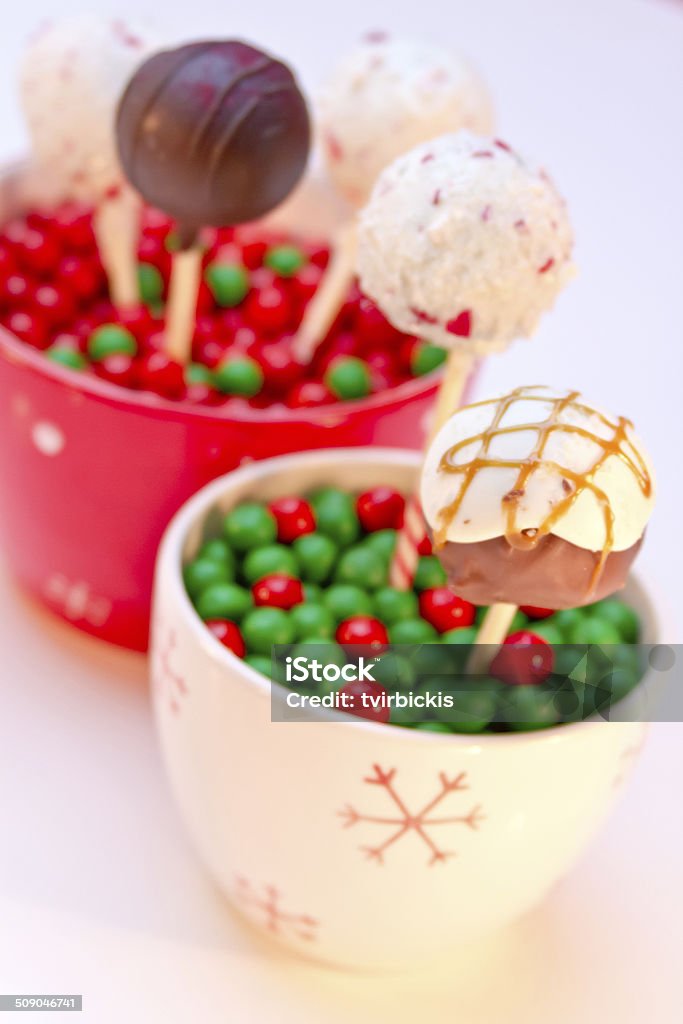 Holiday Cake Pops Display of holiday cake pops in snowflakes mugs with red and green candies on what background Cake Stock Photo