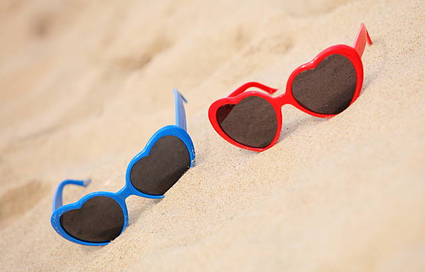 istock Colorful sunglasses shaped heart on the sand 509047569