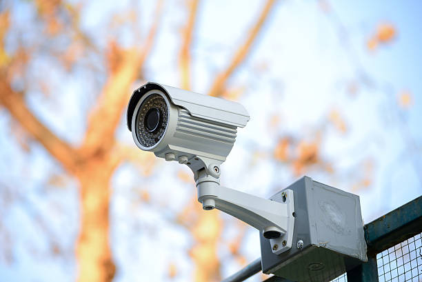 istock Security Camera CCTV over fence blue sky 509048519