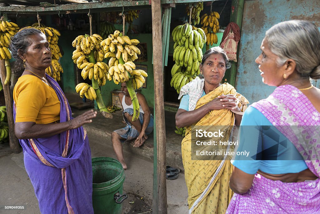 Banana seller Madurai, India - December 26, 2013: Three indian women in traditional colorful sari having a chat in front of a banana shop. Adult Stock Photo