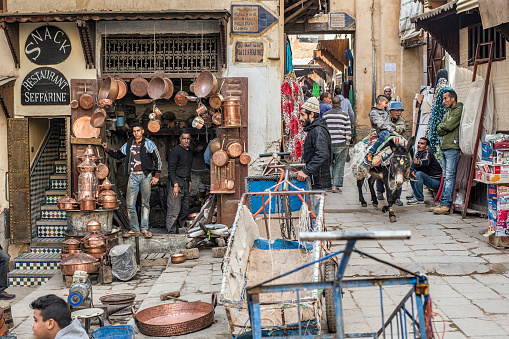 Fez, Morocco - December 14, 2015: Artisans and Citizens in Place Seffarine, metal souk square, in a quotidian scene. 