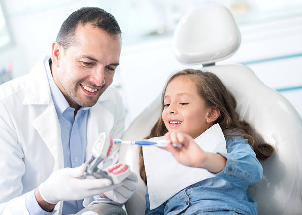 mädchen beim zahnarzt lernen, wie man ihre zähne putzt - human teeth child smiling family stock-fotos und bilder