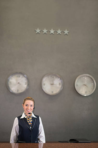 Friendly woman working at a hotel reception and wearing a headset - people traveling concepts