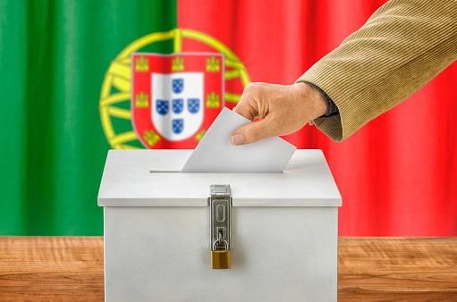 Man putting a ballot into a voting box - Portugal