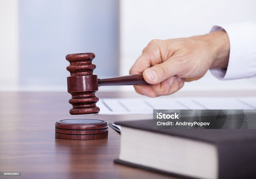 Male Judge In A Courtroom Male Judge In A Courtroom Striking The Gavel Adult Stock Photo